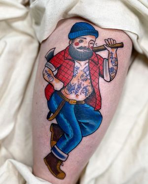 A striking illustrative tattoo on the upper arm featuring an axe-wielding man with a beard, beautifully done by Sofia.