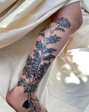 Sofia's blackwork tattoo design of a beautiful flower and leaf on the foot combines elegance and natural beauty.