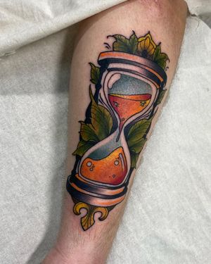 Beautifully detailed tattoo by Sofia featuring an hourglass, leaf, and sand elements, perfect for a unique and meaningful design.