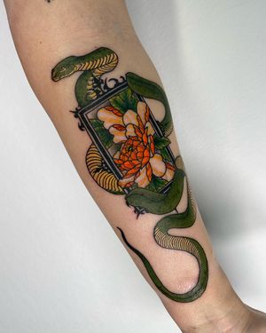 Stunning illustrative tattoo by Sofia featuring a snake intertwining with a chrysanthemum flower design on the forearm.