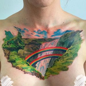 Vibrant watercolor chest tattoo by Brigid Burke featuring a stunning rainbow waterfall design.