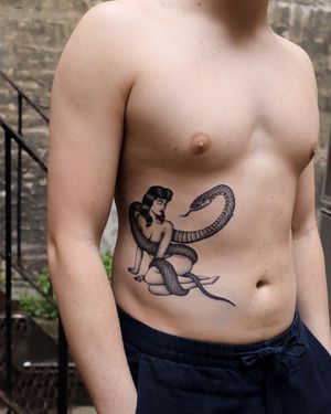 Elegant blackwork and fine line design by Jeppe Dahl Rørdam, featuring a beautiful snake and woman illustration.