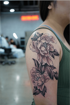 Elegant and bold illustrative peony flower tattoo by Kotaro, perfect for upper arm placement.