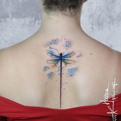 A stunning illustrative upper back tattoo featuring a vibrant watercolor dragonfly and intricate pattern by artist Houssam.