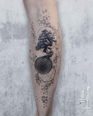 Unique blackwork tattoo on lower leg by tattoo artist Houssam, featuring a detailed tree and world design in dotwork and fine line style.