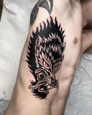 Experience the artistry of Andre Bertoncin with this bold blackwork wolf design on your ribs.