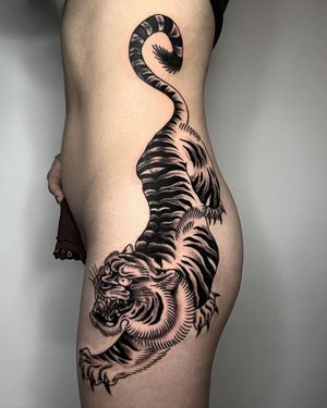Experience the power and grace of a traditional blackwork tiger tattoo by the skilled hands of Andre Bertoncin on your ribs.