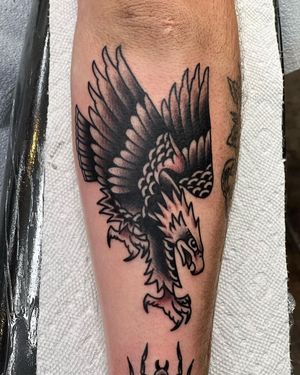 Get a stunning illustrative blackwork eagle tattoo on your shin, expertly done by Shawn Nutting. Stand out with this bold and powerful design.