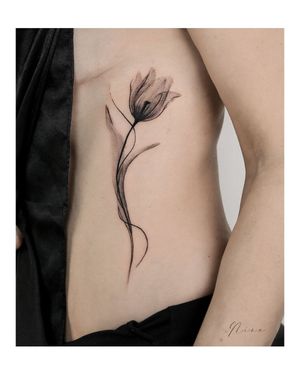 Elegant blackwork and illustrative design on ribs featuring intricate flower motif and delicate patterns. Perfect for those seeking a unique and stylish tattoo. By talented artist Nina.