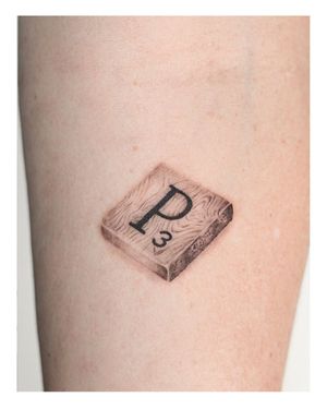 Nina's blackwork style combines lettering and illustrative details in this striking forearm tattoo motif.
