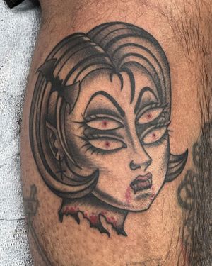 Illustrative blackwork tattoo of a mysterious vampire woman with bat motif by Shawn Nutting on arm.