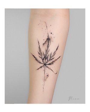 This blackwork illustrative tattoo features a delicate leaf design, expertly executed with fine line details on the forearm by tattoo artist Nina.