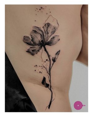 Experience the delicate beauty of blackwork and illustrative style in this stunning floral rib tattoo by Nina.