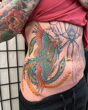 Incredible illustrative design by Daniel Werder, featuring a vibrant phoenix rising from the ashes on the stomach.