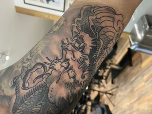Experience the fierce power of a blackwork Japanese dragon tattoo on your arm by talented artist Frankie Brown.