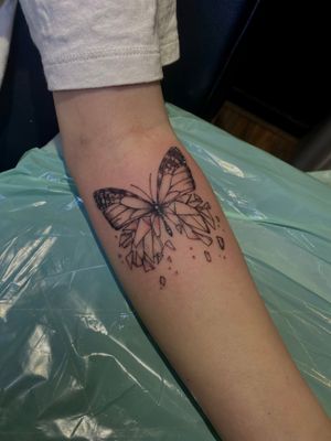 Intricate fine line design by Frankie Brown, blending geometric shapes with delicate butterfly motif for a unique forearm tattoo.