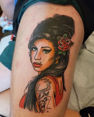 Classic traditional lettering tattoo on upper arm featuring a flower inspired by Amy Winehouse with a meaningful quote by Arlene Salinas.