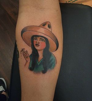 Illustrative forearm tattoo of a woman wearing a hat and smoking a cigarette, by artist Arlene Salinas.
