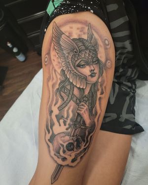 Blackwork tattoo on upper leg featuring a skull, woman, sword, helmet, and smoke by Arlene Salinas.
