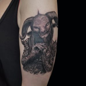 Unique blackwork tattoo of a horned faun done by Arlene Salinas, perfect for arm placement.