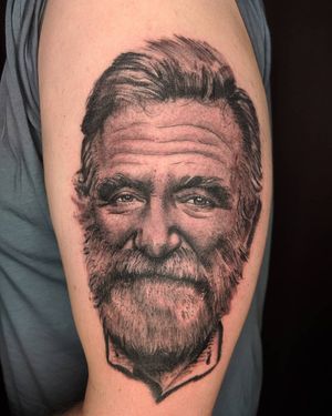 Realistic illustration of a man with beard paying homage to the legendary Robin Williams by Arlene Salinas on upper arm.