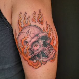 Get a fiery neo-traditional skull tattoo on your upper arm by the talented artist Arlene Salinas. A bold and dynamic design that will stand out.