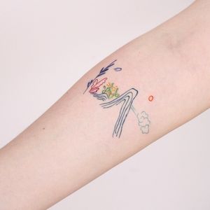 Fine line and illustrative forearm tattoo featuring a sun, mountain, and flower design by Tuğçe özbıyık.