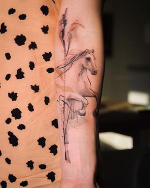 Experience the artistry of La Bottega dell'Arte with this stunning blackwork tattoo featuring a majestic horse and intricate pattern on your forearm.
