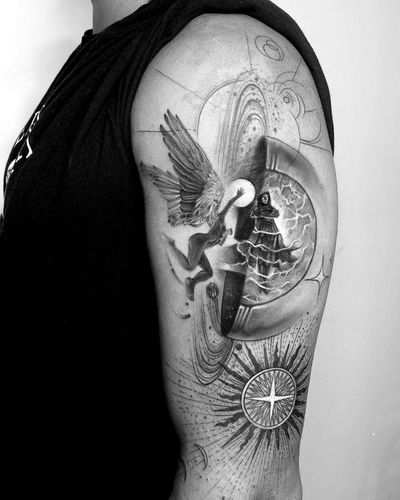 A captivating blackwork and fine line upper arm tattoo by Murat Yılmaz featuring a planet and compass motif with ornamental geometric patterns and angelic wings.