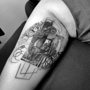 Blackwork and fine line upper arm tattoo featuring a geometric elephant and leopard design by Murat Yılmaz.