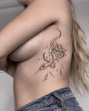 Beautiful blackwork tattoo on ribs by Nika Shvets featuring a snake and flower design.