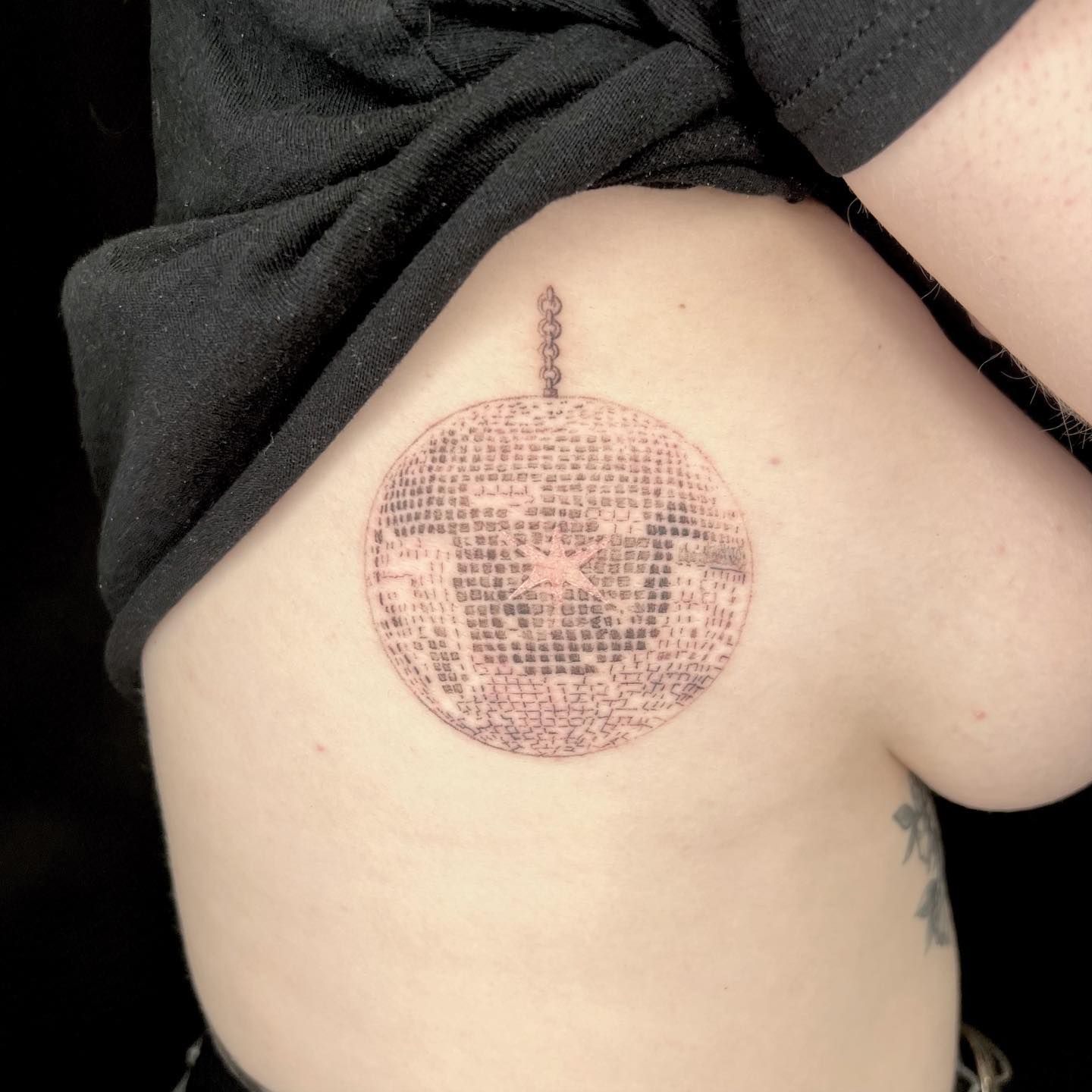 Fine line disco ball tattoo on the tricep