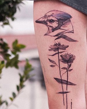 An illustrative tattoo by Osman Ergin combining a bird and flower design in fine line blackwork style on the upper leg.