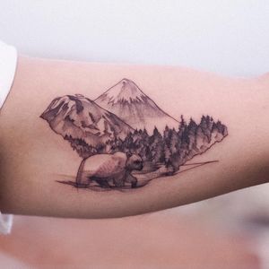An intricate blackwork and illustrative tattoo featuring a majestic mountain, fierce bear, and towering tree, by renowned artist Osman Ergin.
