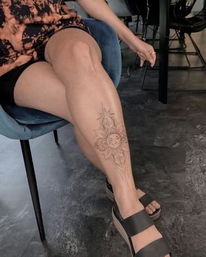 Experience Nika Shvets' fine line illustration of a mesmerizing geometric sun mandala on your shin. A unique tattoo that combines intricate patterns and symbolic sun motif.