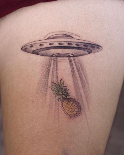 Check out this unique blackwork tattoo by Osman Ergin, featuring a pineapple and spaceship motif on the upper leg.