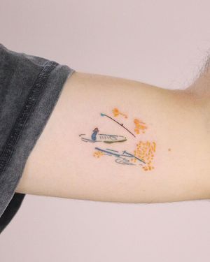 Illustrative upper arm tattoo of a boat and hat symbolizing adventure and freedom. By Tuğçe özbıyık.