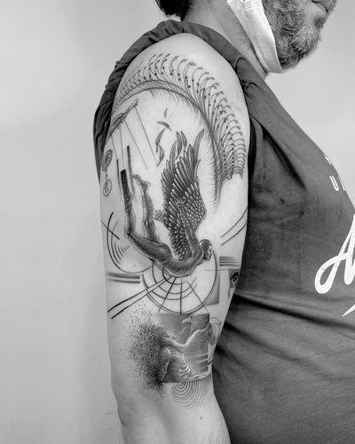 A stunning blackwork design by Murat Yılmaz, featuring intricate fine line patterns and geometric shapes that form angel wings on the upper arm.