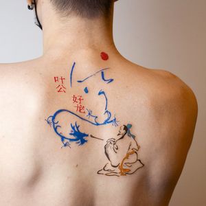 A stunning upper back tattoo by Tuğçe özbıyık featuring a fine line illustrative design of a dragon, man, kanji, and a meaningful quote.