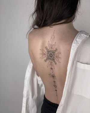 Elegant blackwork design on the back, combining geometric shapes, intricate patterns, and a beautiful lotus flower.