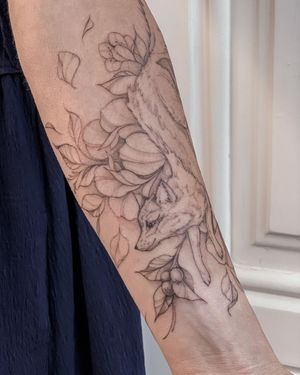 Elegant forearm tattoo featuring a detailed fox and delicate flower, created by Nika Shvets in an illustrative style.