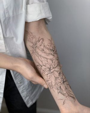 Bold blackwork forearm tattoo by Nika Shvets featuring a stunning mix of geometric dragon and flower motifs.