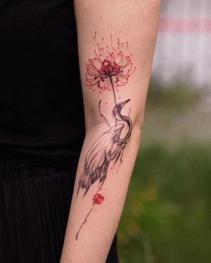 Get a stunning blackwork tattoo of a heron and flower on your arm by the talented artist Osman Ergin.