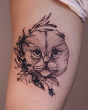 Illustrative upper arm tattoo featuring a cat and flower motif, done by Osman Ergin.