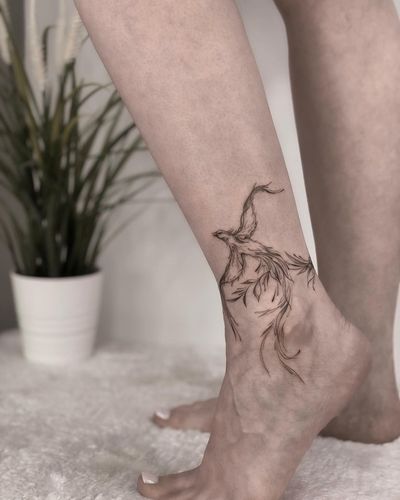 Ankle tattoo by Nika Shvets featuring a stunning phoenix design in fine line and geometric style.