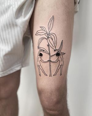 Beautiful illustrative tattoo featuring a delicate flower and a man, artfully done by Kaśka. Perfect for the upper arm.