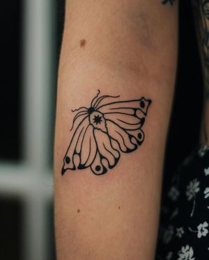 Get a stunning blackwork butterfly tattoo on your upper arm by Kaśka. This illustrative design is sure to make a statement.