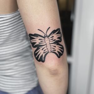 Express your inner beauty with a stunning blackwork butterfly tattoo on your upper arm, created by the talented artist Kaśka.