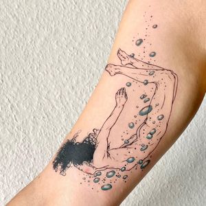Exquisite upper arm tattoo featuring water element and woman in fine line illustrative style by artist Magdalena Sawicka.