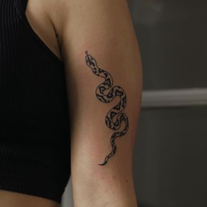 Unique blackwork design featuring a snake, expertly done by tattoo artist Kaśka. Perfect for those seeking a bold and stylish tattoo on their upper arm.